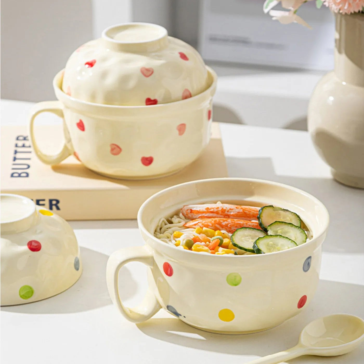 Ceramic kawaii ramen bowls with polka dot design on a table with food inside.