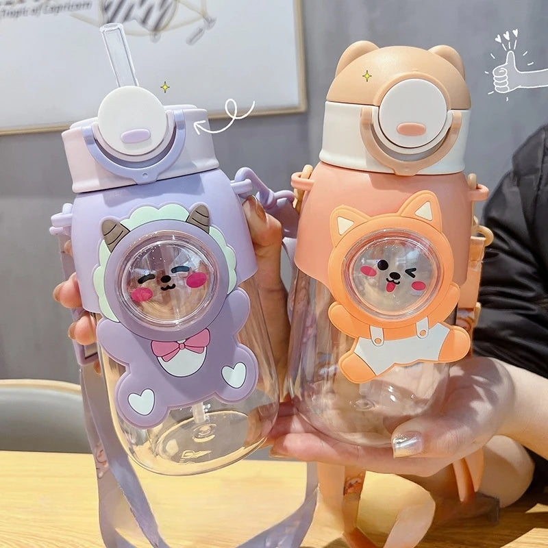 Two cartoon-themed kawaii water bottles held by a person with a blurred background.