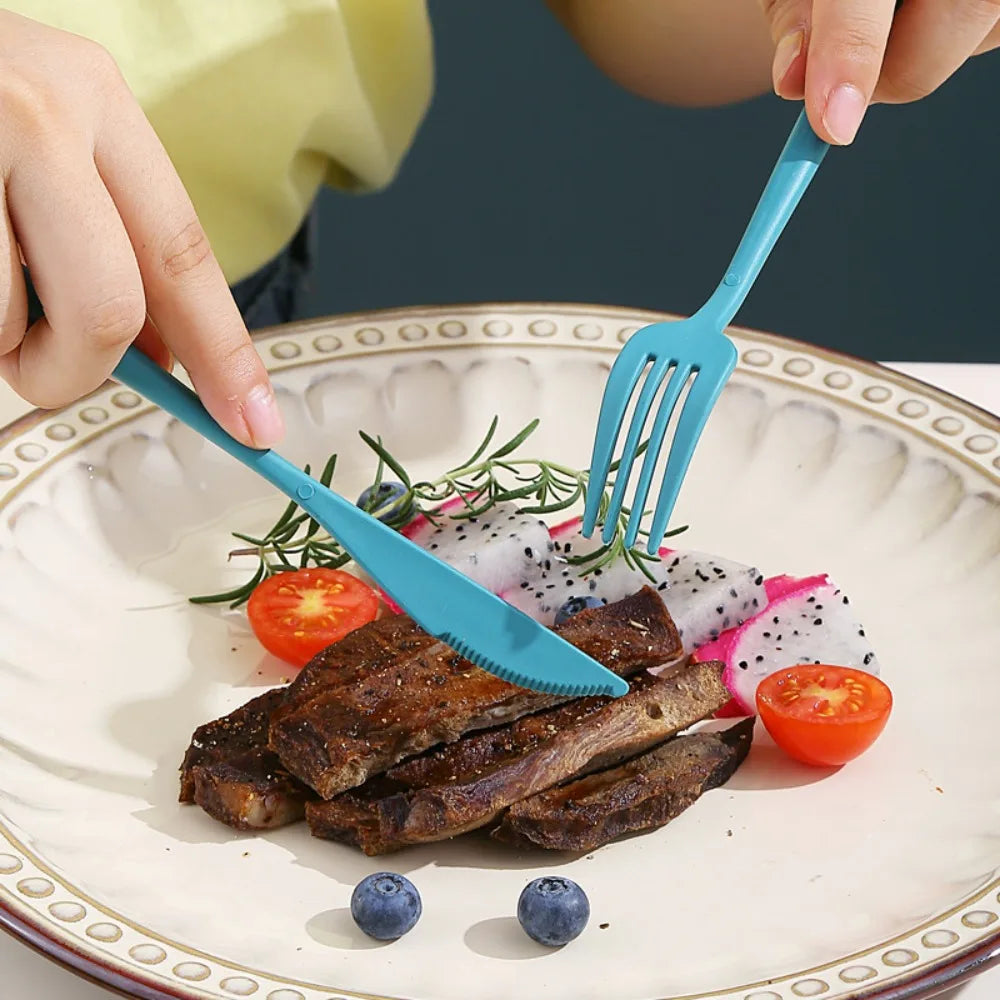 Person using blue plastic kawaii utensils to eat a plate of meat and vegetables.