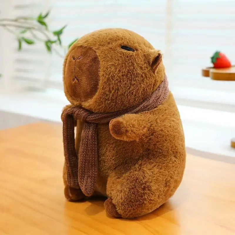 Brown kawaii plush toy with a scarf on a wooden surface
