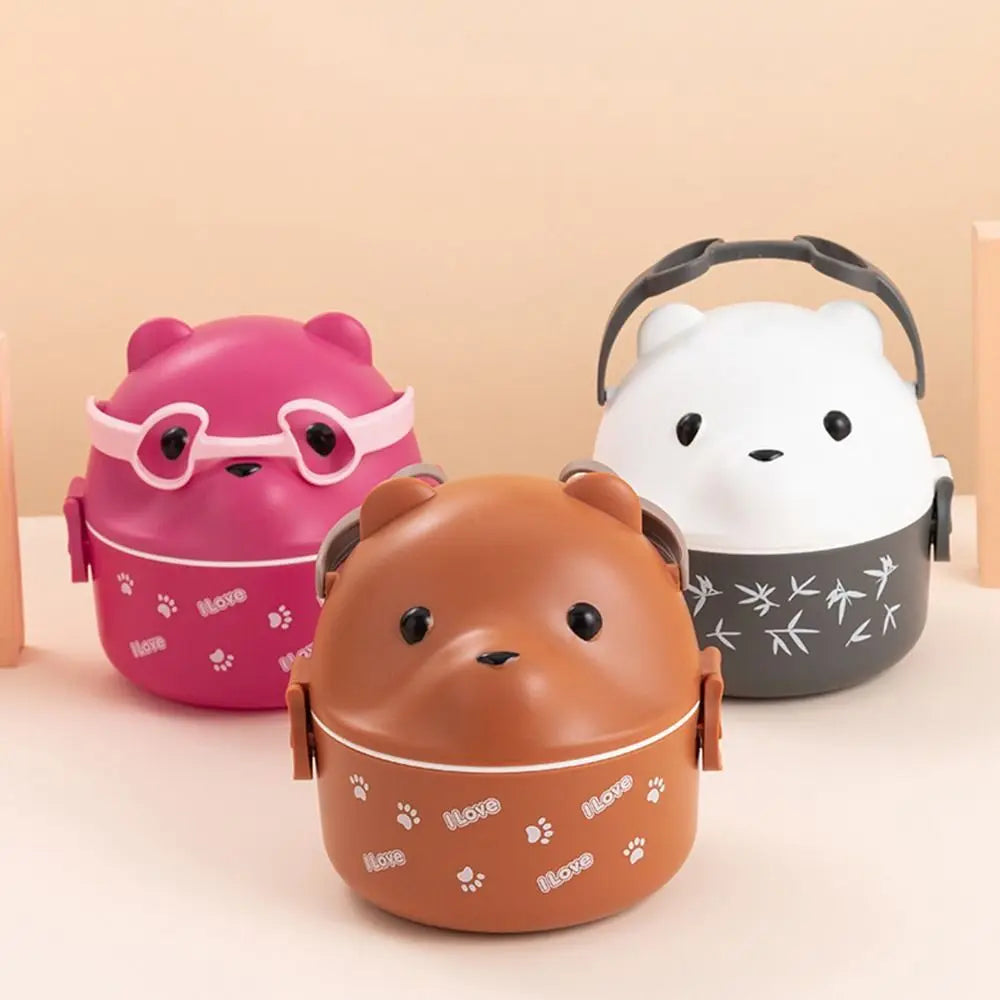 Three animal-themed kawaii lunch boxes in pink, brown, and white on a beige background