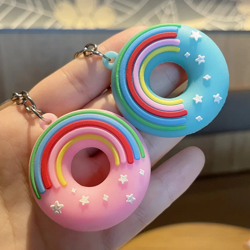 Colorful rainbow kawaii donut keychains held in a hand with a blurred background