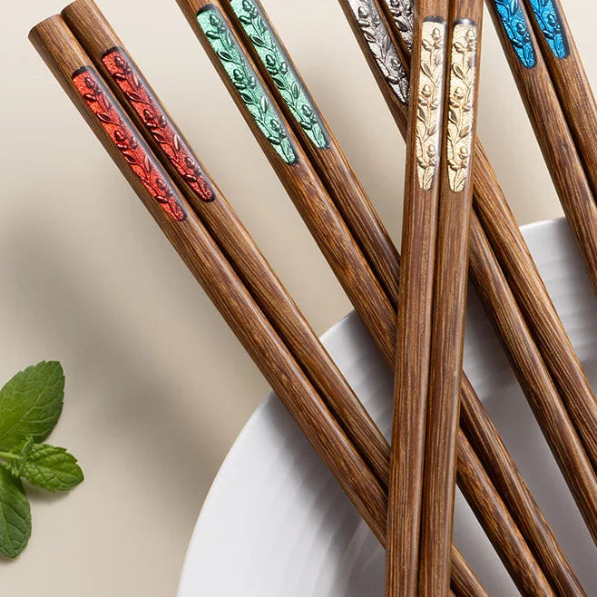 Wooden kawaii chopsticks with decorative ends on a neutral background
