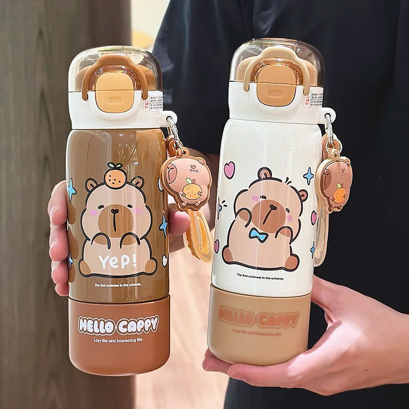 Two cartoon-themed kawaii water bottles held by a person, with keychains attached.