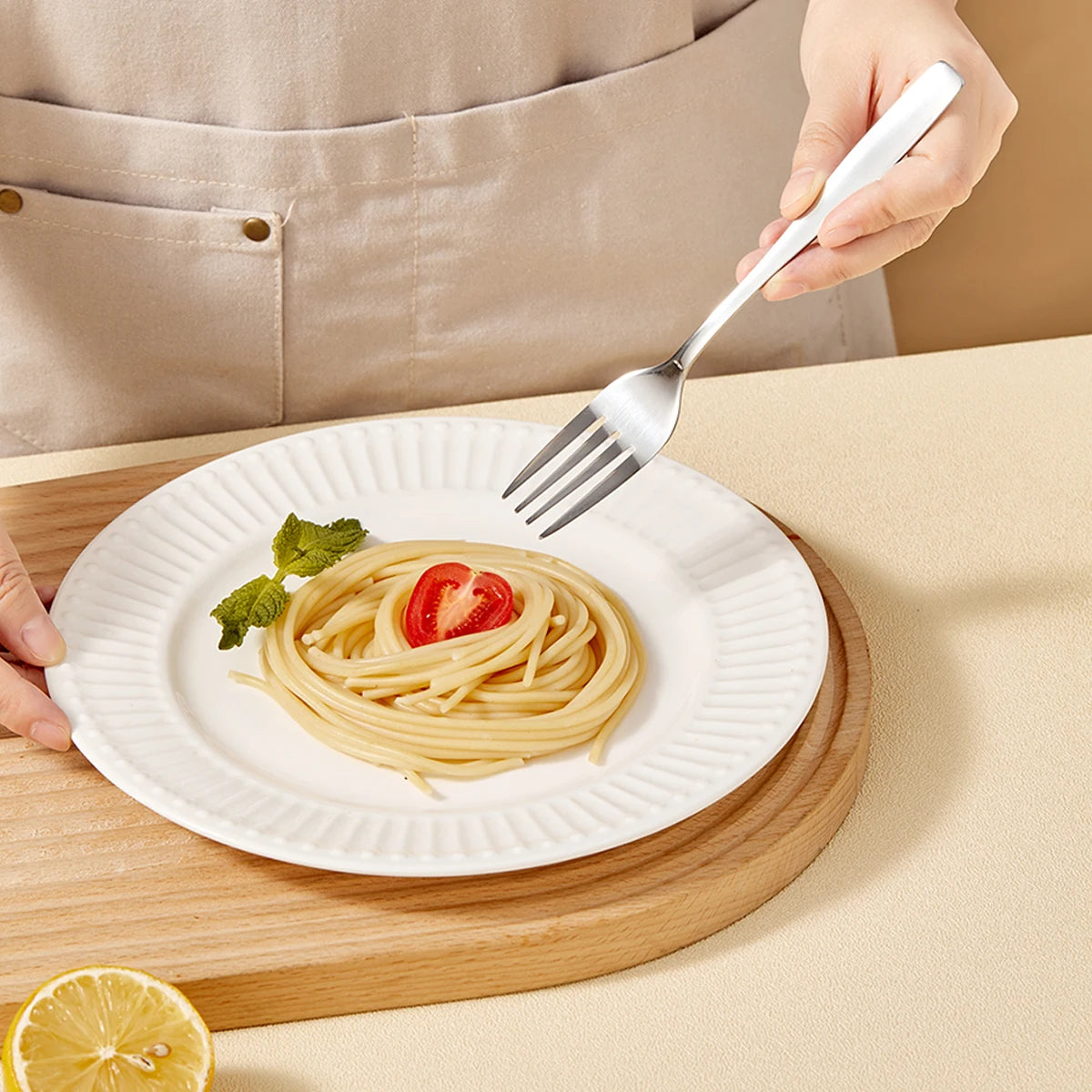 Person holding a kawaii utensil over a plate of spaghetti with a lemon wedge on a wooden board.