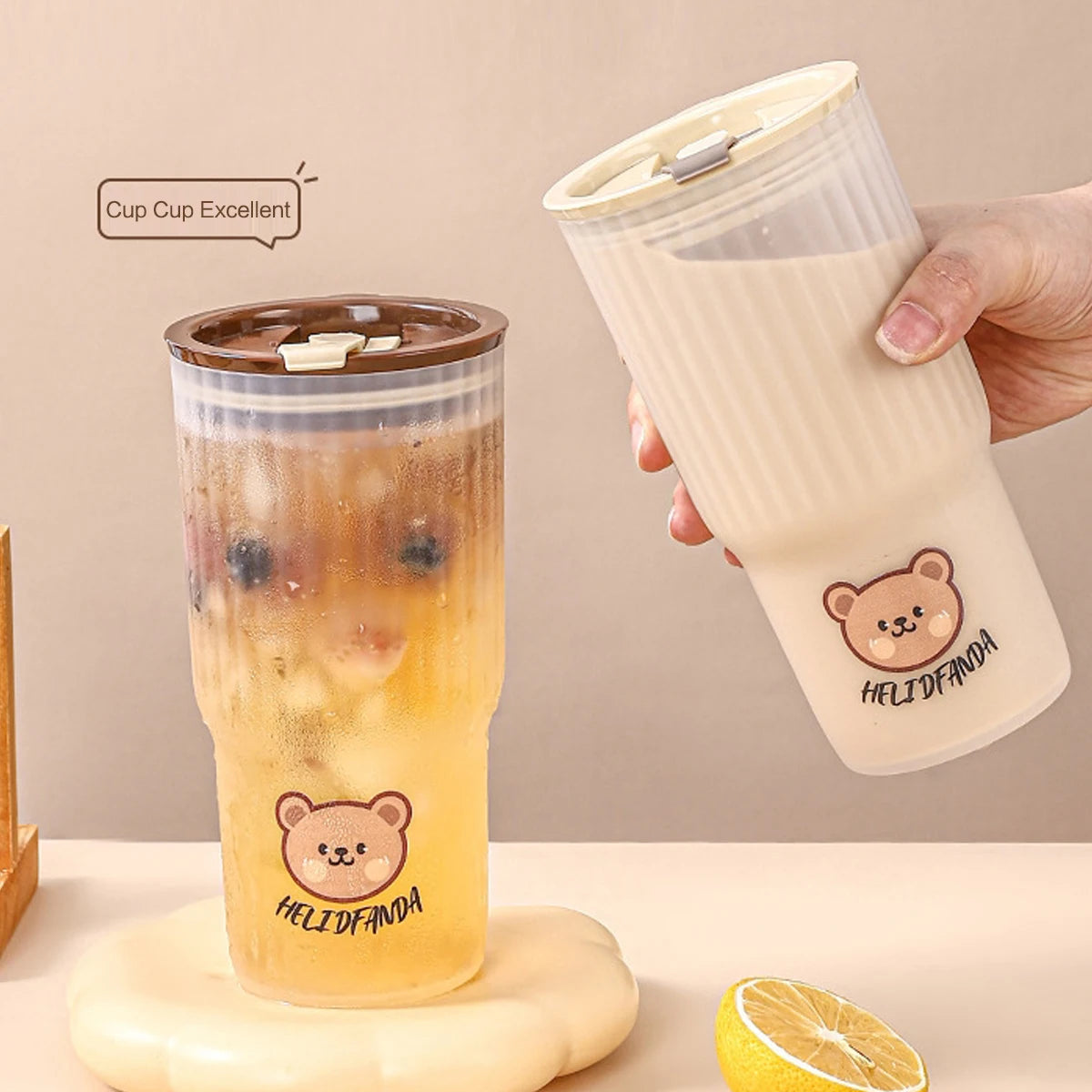 Two bear-themed kawaii cups with one being held by a hand, on a neutral background.