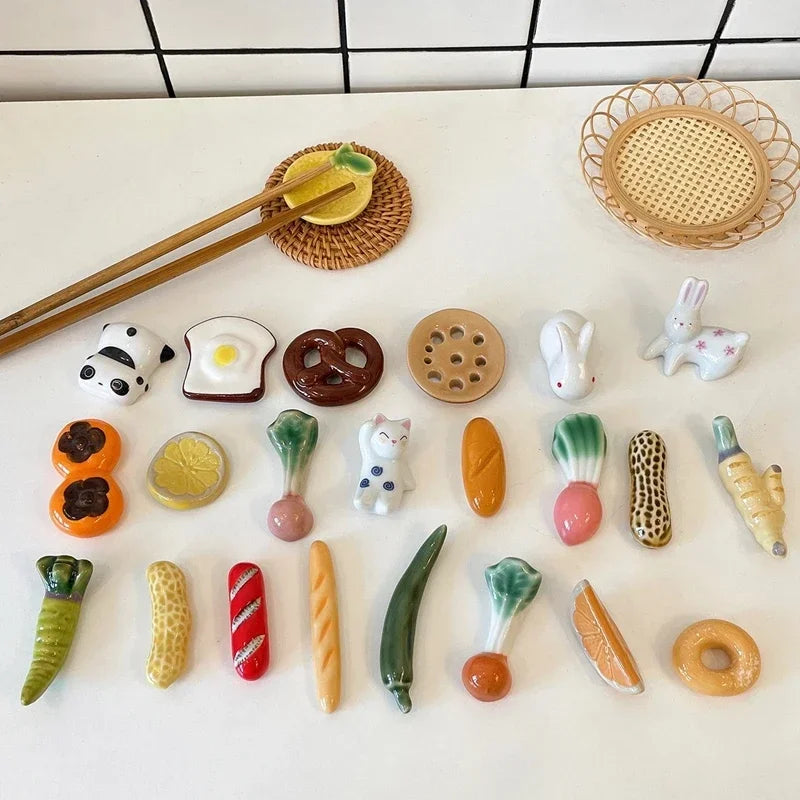Collection of ceramic food kawaii chopstick holders on a white surface with a tiled background