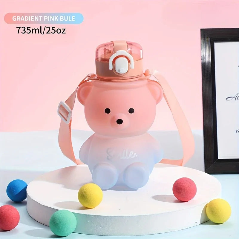 Gradient pink kawaii water bottle with bear design on a white surface with colorful balls.