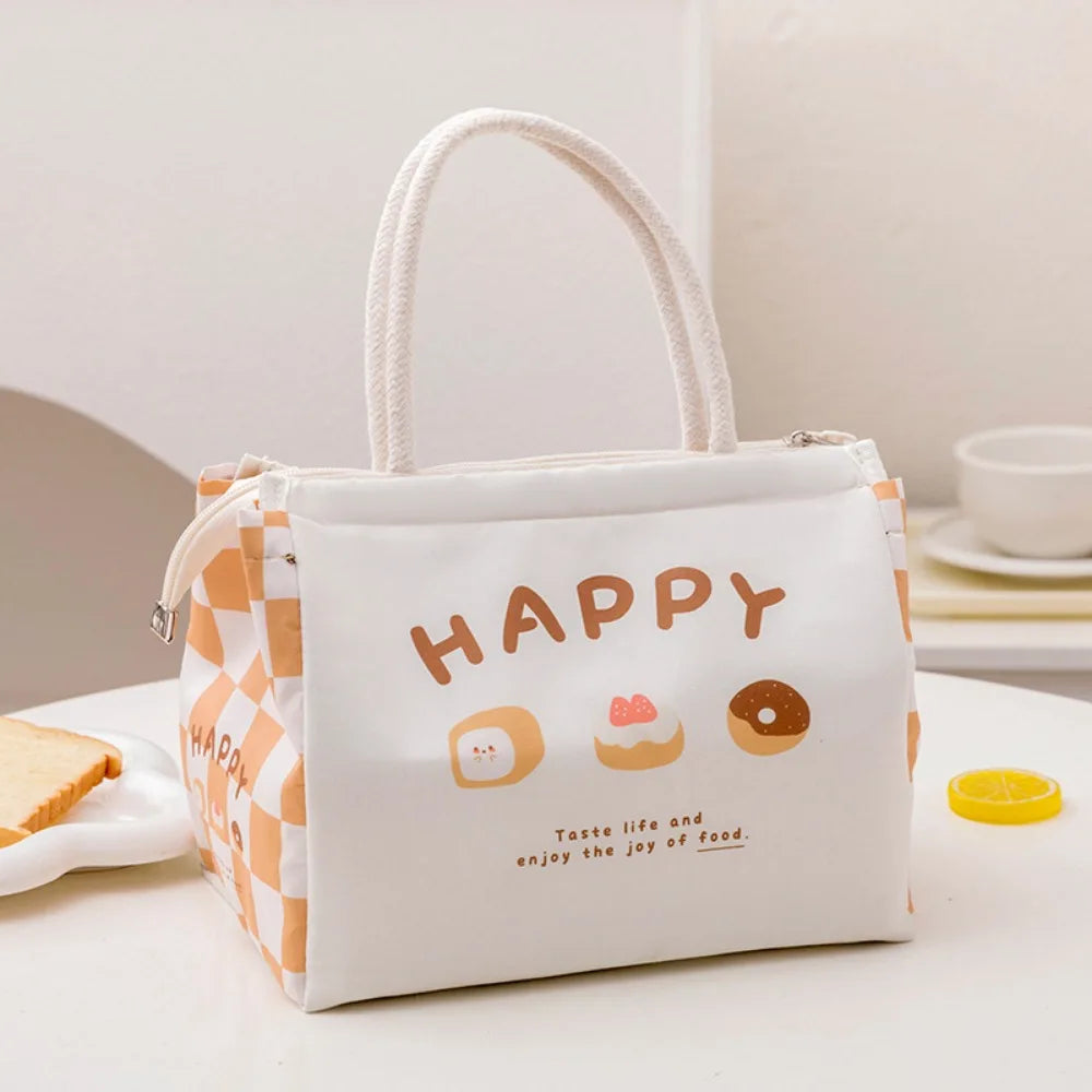 Kawaii lunch bag with 'Happy' and food illustrations on a table with a sandwich and snacks.