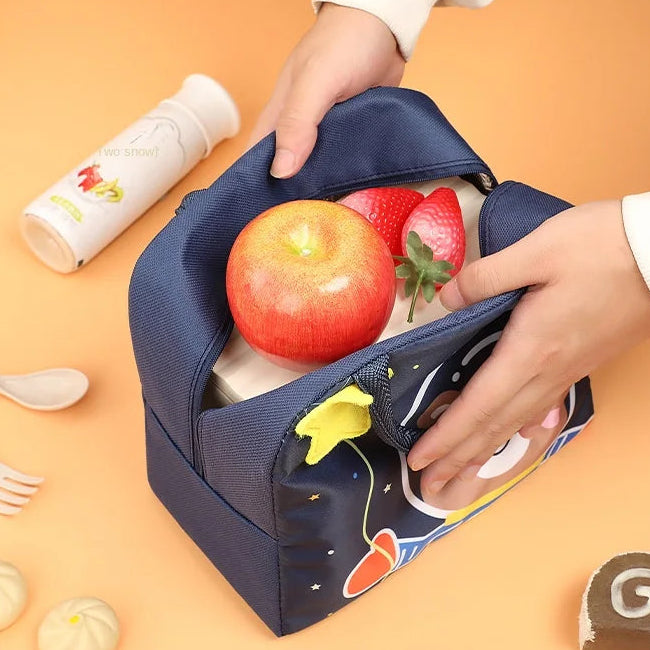 Person holding a blue kawaii lunch bag with food items on an orange background