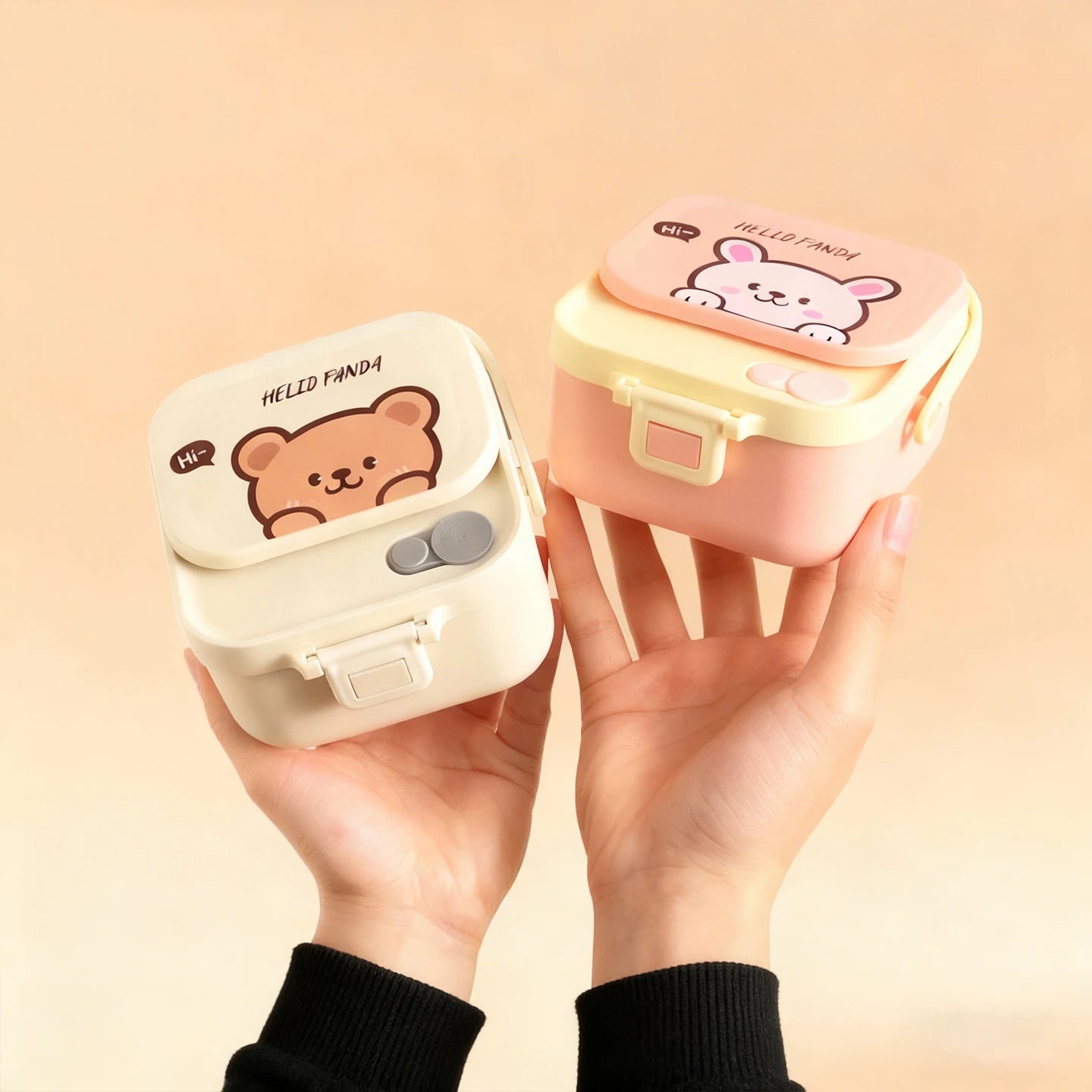 Two small, cute kawaii containers with bear designs held by a hand against a beige background