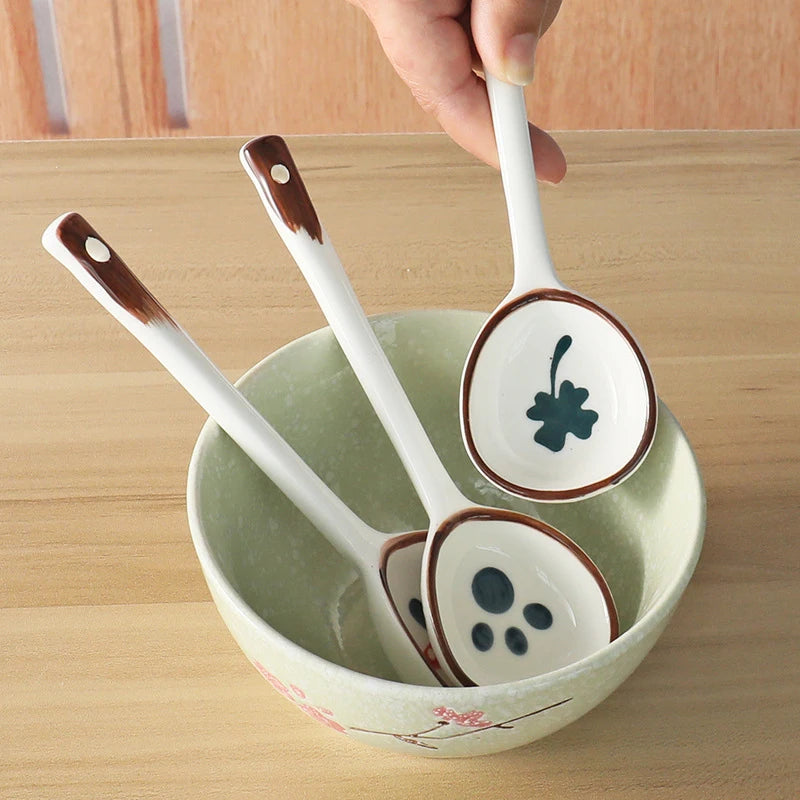 A person holding a white ceramic kawaii spoon with a glover on it