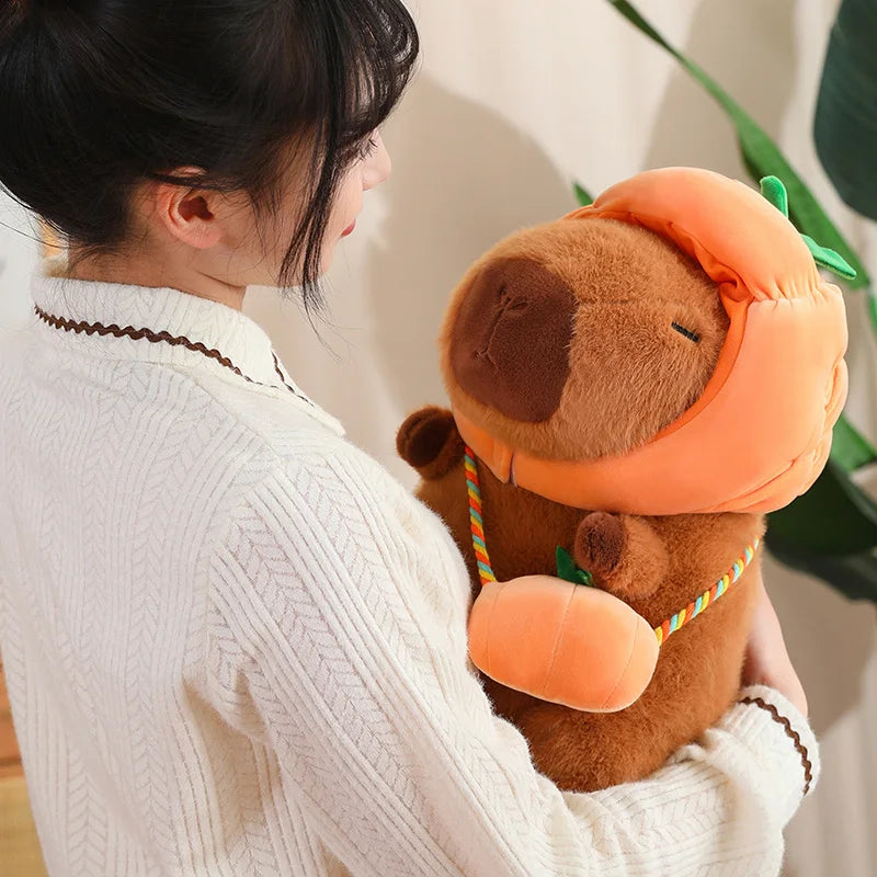 Person holding a kawaii plush toy resembling a bear with an orange hat indoors