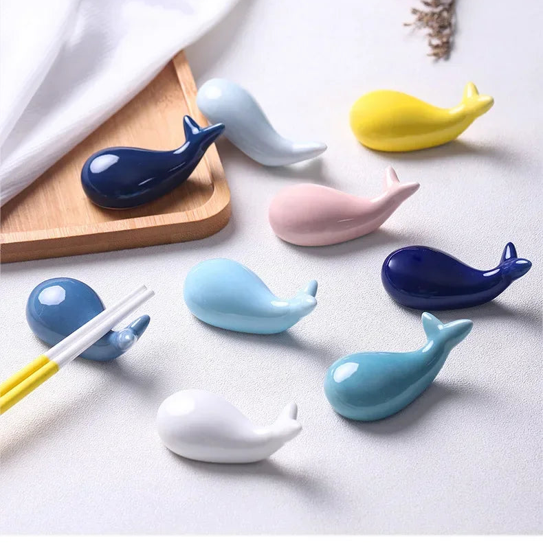 Set of whale-shaped ceramic kawaii chopstick holders on a white surface with text in Chinese.