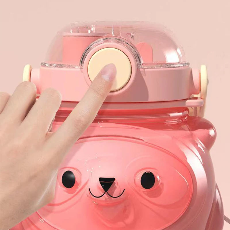 Pink bear-shaped kawaii water bottle with a hand pressing a button on a pink background