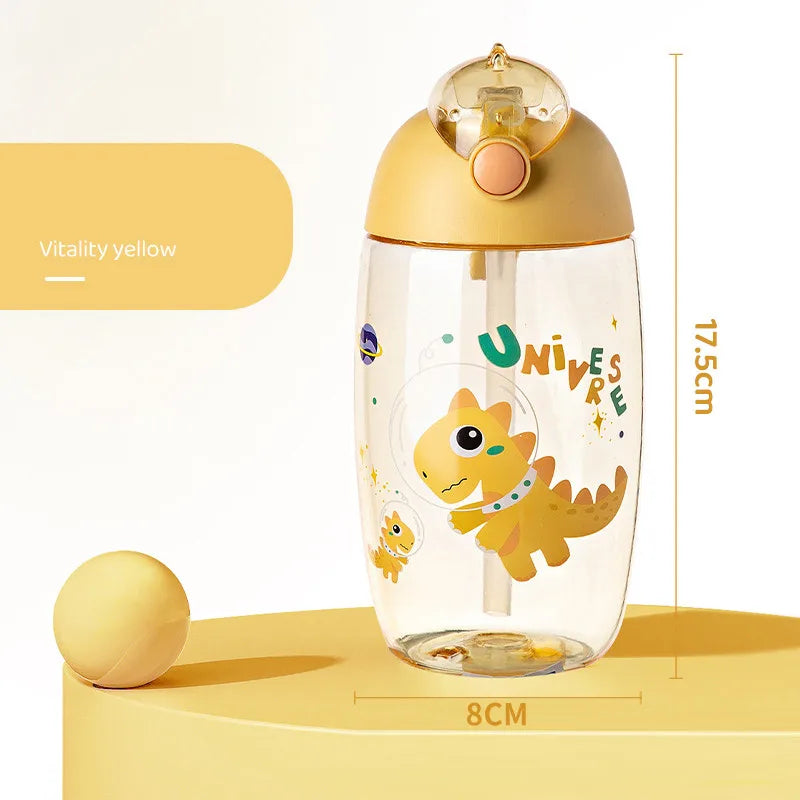 Clear kawaii water bottle with dinosaur design and gold lid on a yellow background