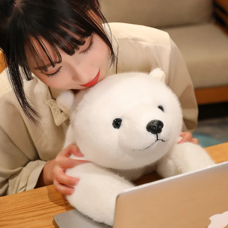 Person hugging a large white kawaii plush toy in front of a laptop on a wooden table.