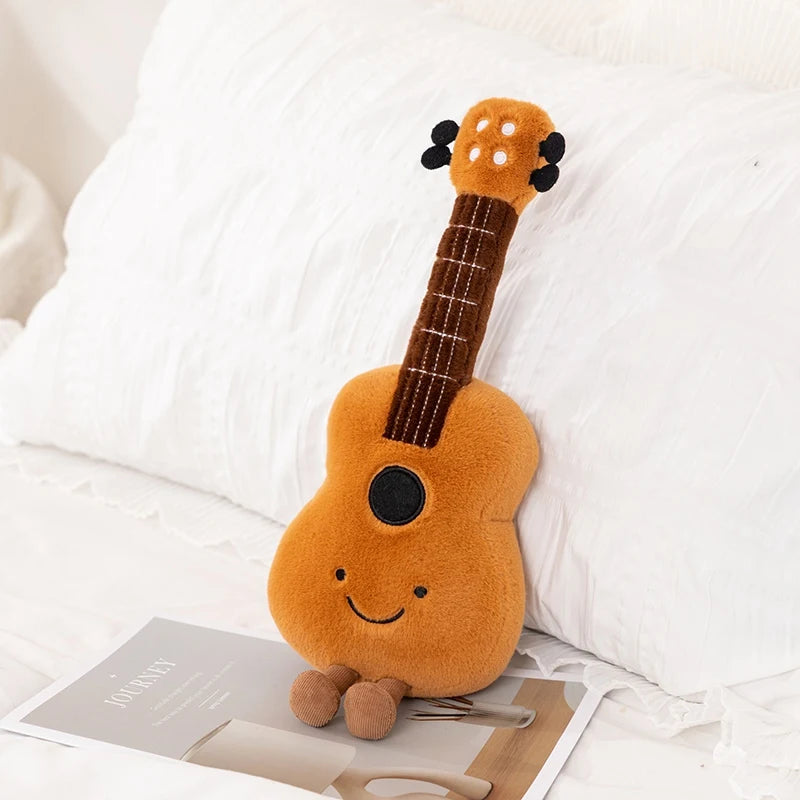 Kawaii plush toy guitar with a smiling face on a white surface