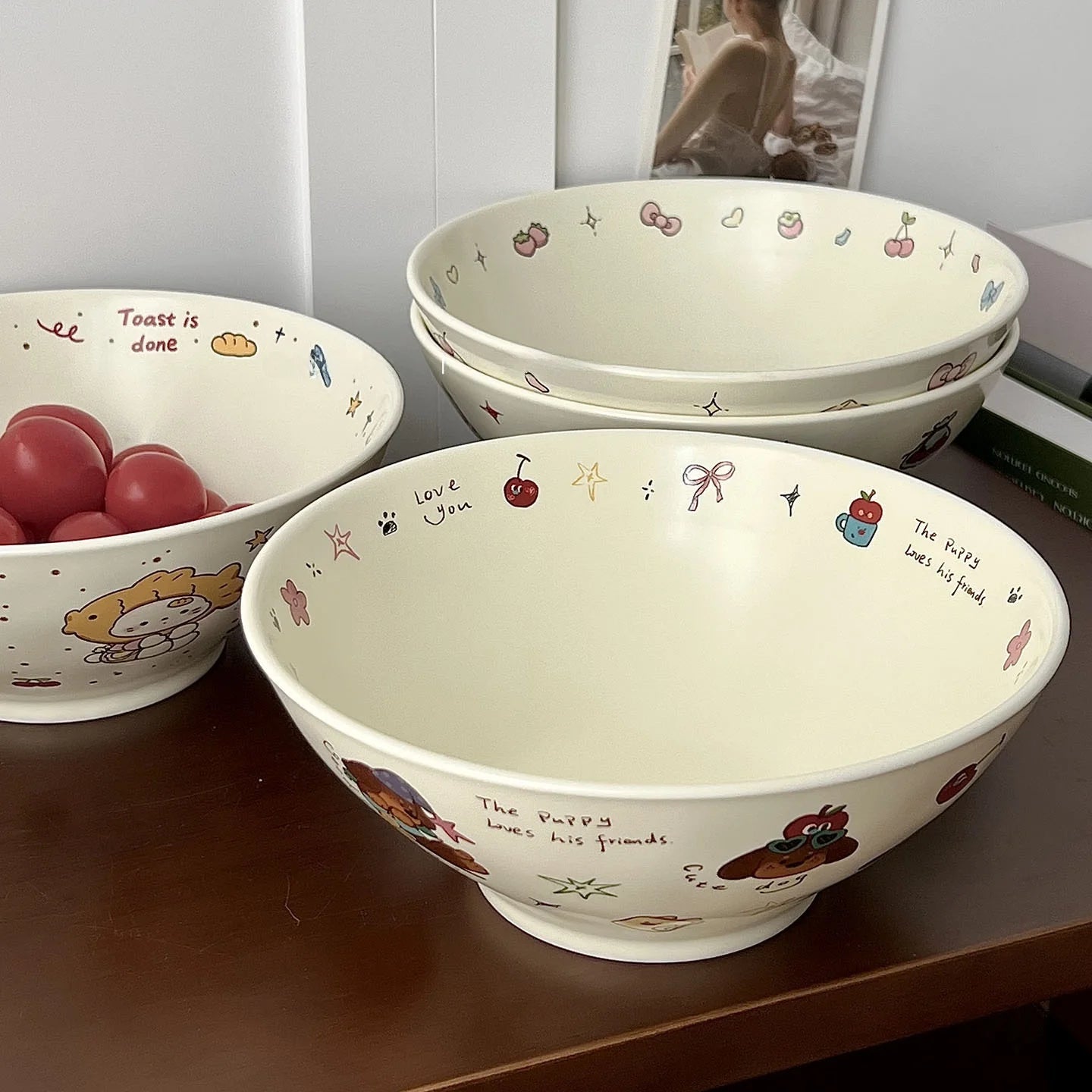 Set of three ceramic kawaii ramen bowls with cartoon designs on a wooden surface.