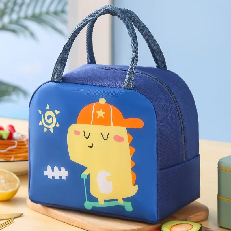 Blue kawaii lunch bag with a cartoon dinosaur design on a wooden table.