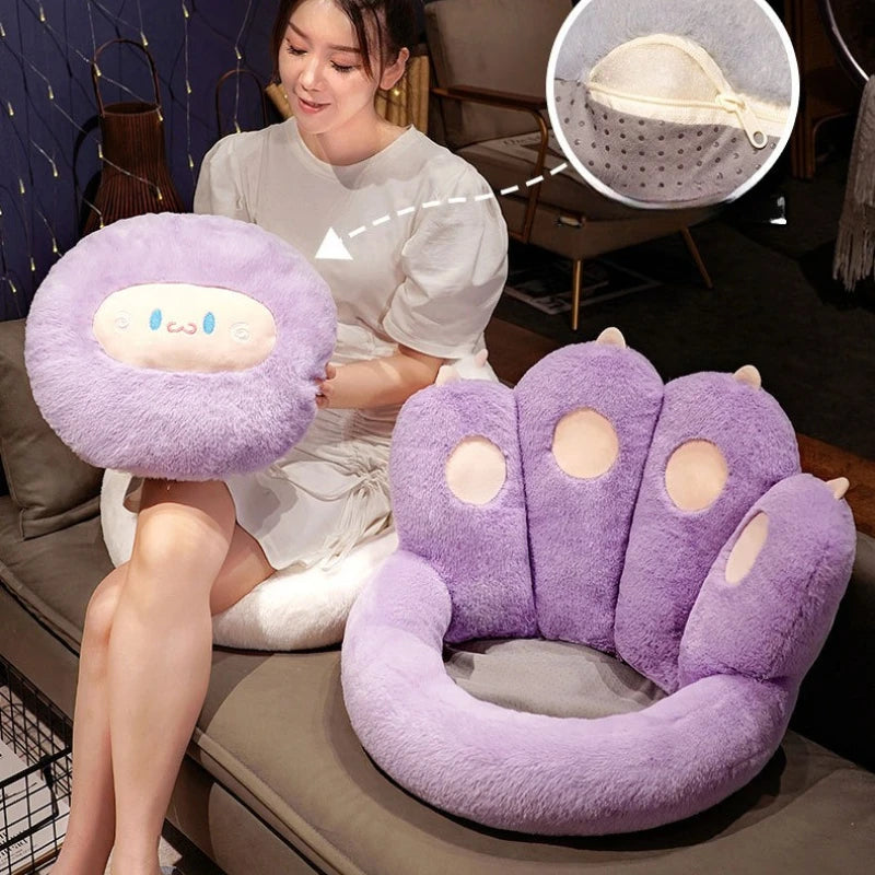 Person holding a purple plush chair with a small kawaii plush toy on a couch.
