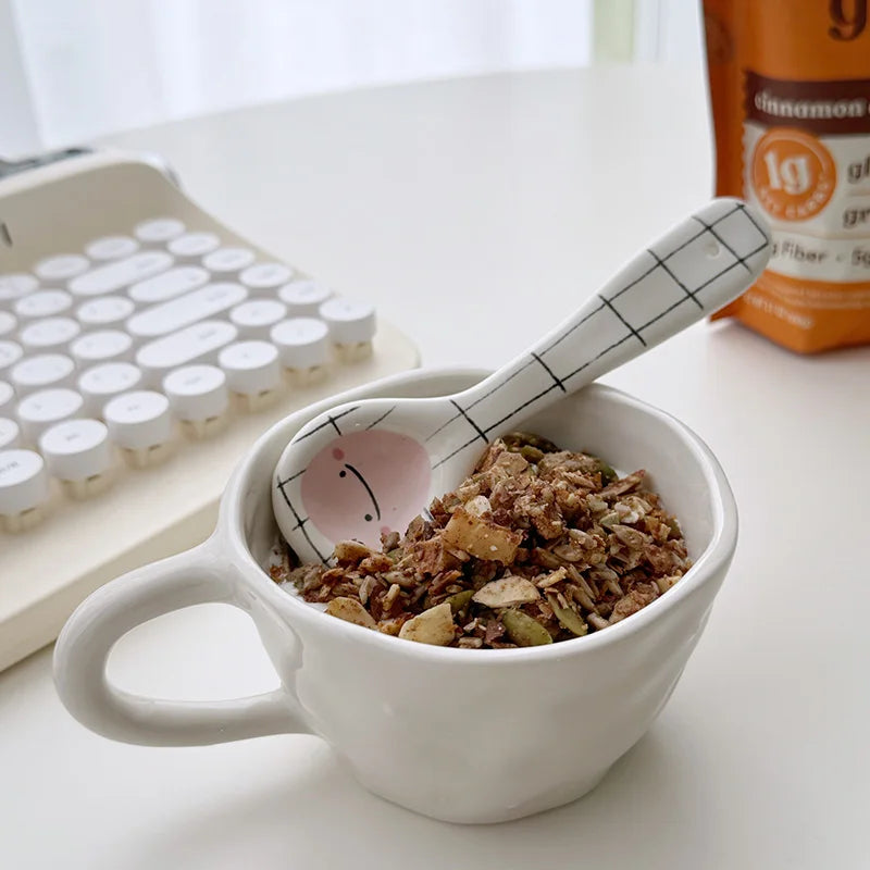 A white and black kawaii spoon inside a mug