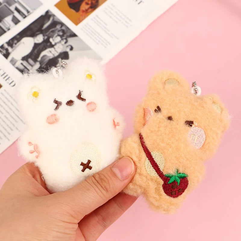 Hand holding a small kawaii plush toy with a pink background