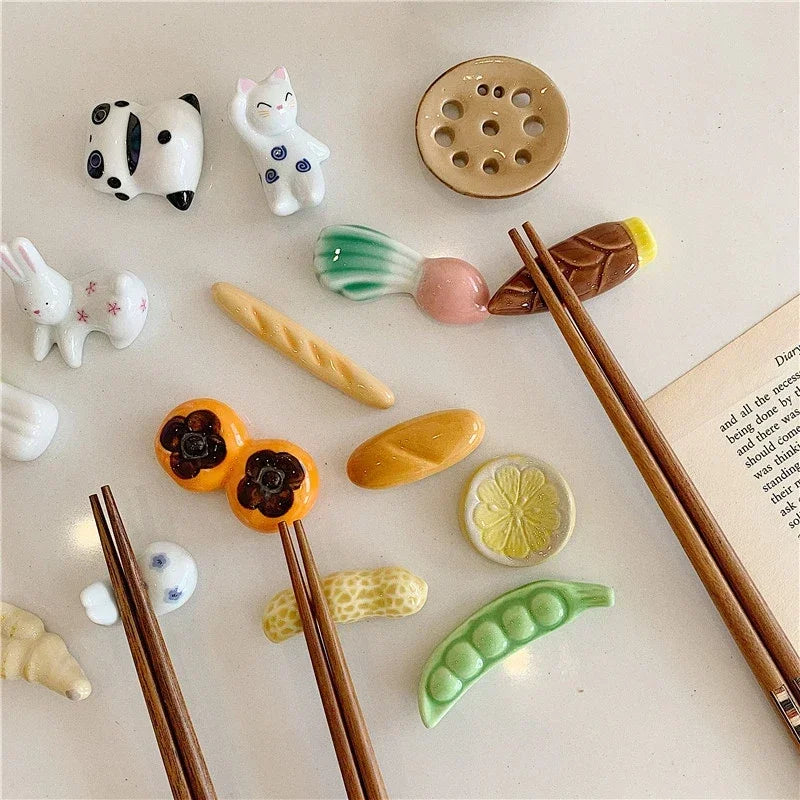 Set of ceramic food-shaped kawaii chopstick holders with chopsticks on a light surface