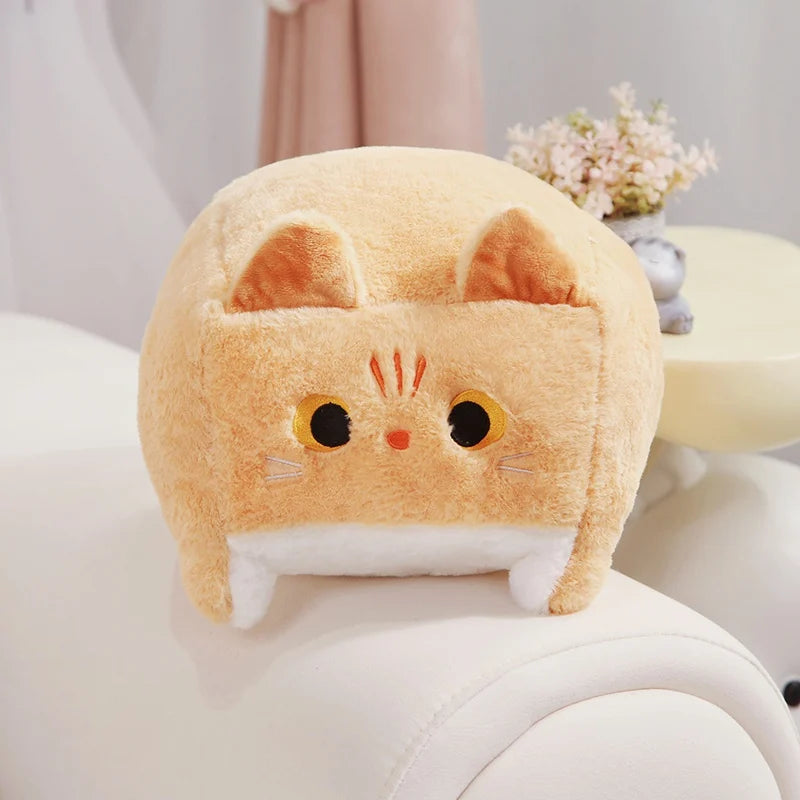 Plush cat-shaped kawaii cushion on a white surface with a blurred background