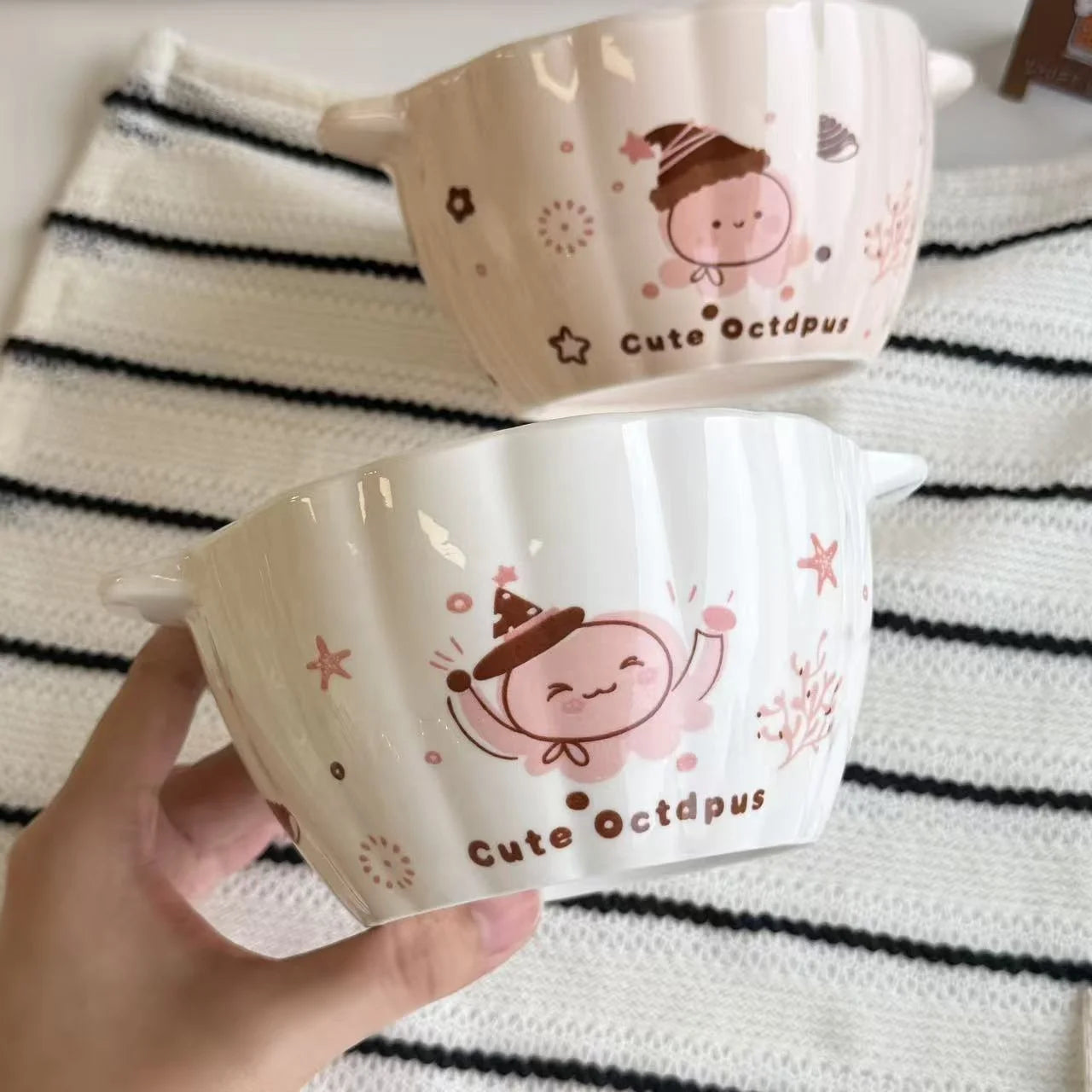 Two ceramic kawaii ramen bowls with 'Cute Octopus' design on a striped fabric background