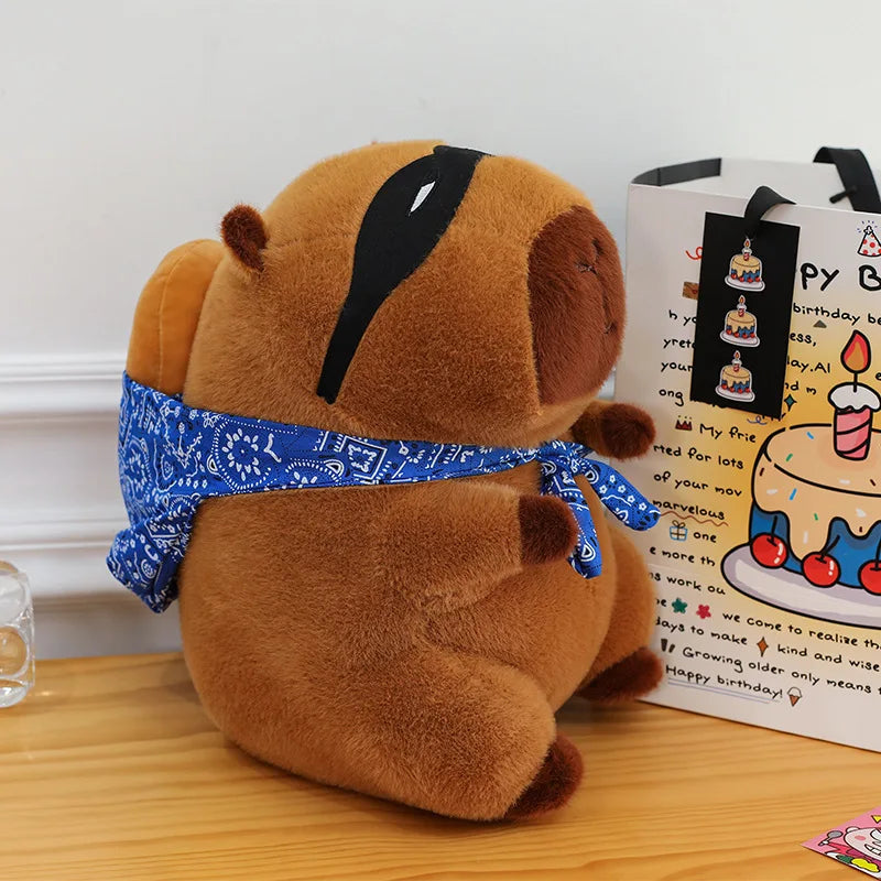 Kawaii plush dog toy with a blue bandana on a wooden surface next to a birthday card.