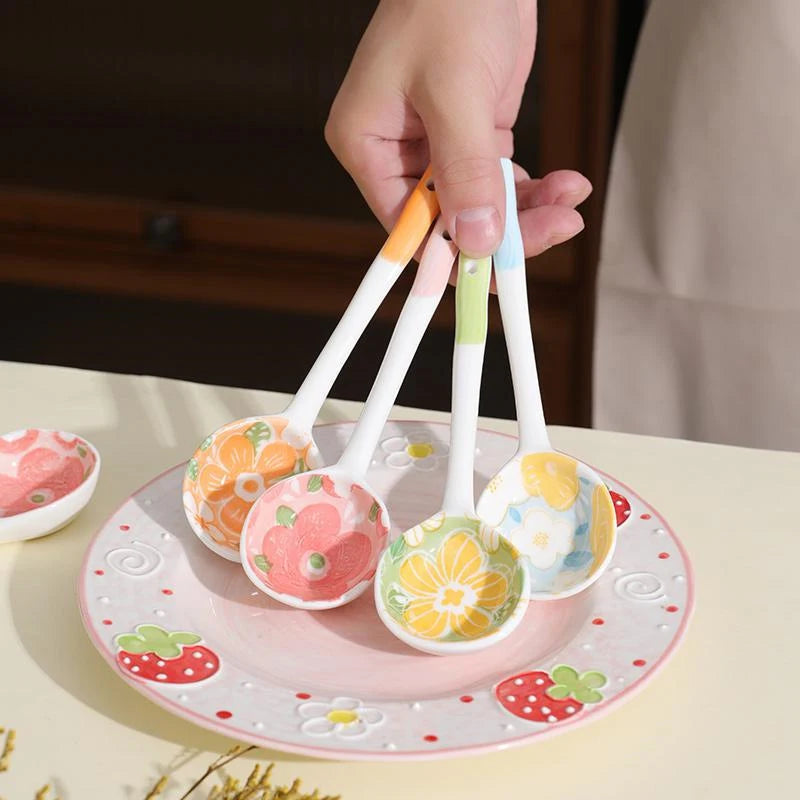 A person holding four flower designed kawaii spoons