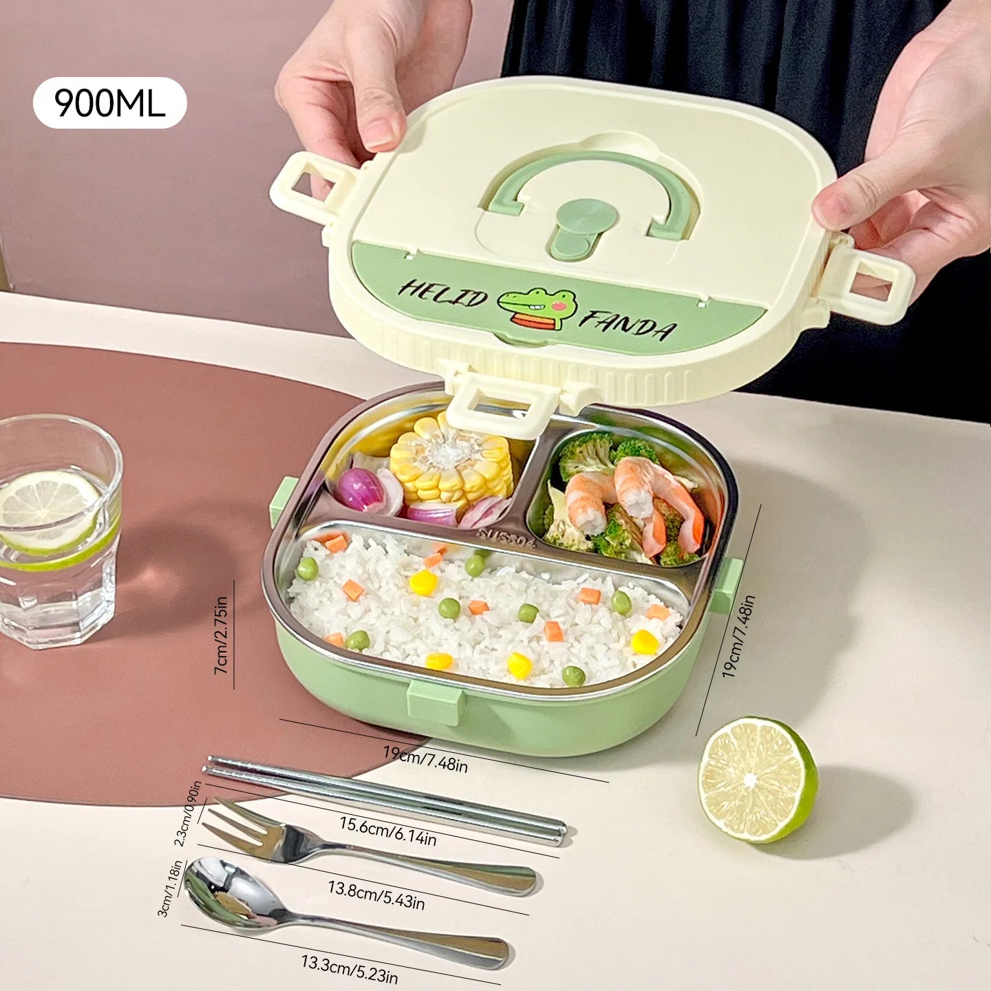 Green kawaii lunch box with compartments filled with food, held open by a hand on a pink surface.