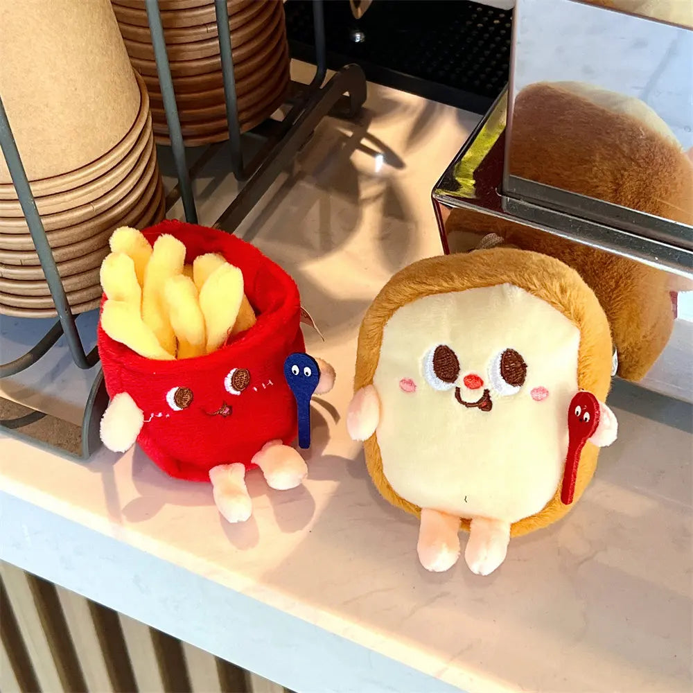 Plush kawaii toys of a bucket of fries and a sandwich with a smiley face on a reflective surface.