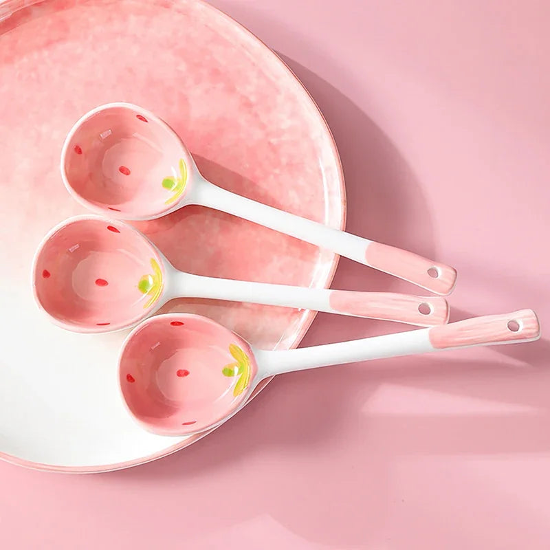 Three pink strawberry designed kawaii spoons on a table