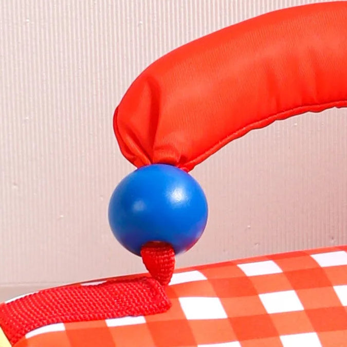 Red and blue ball with a checkered kawaii lunch bag on a plain background