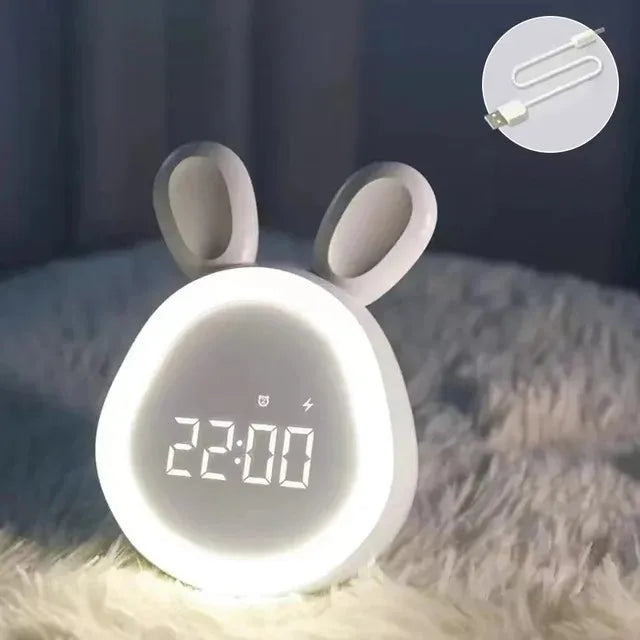 Digital clock with kawaii rabbit ears on a soft surface