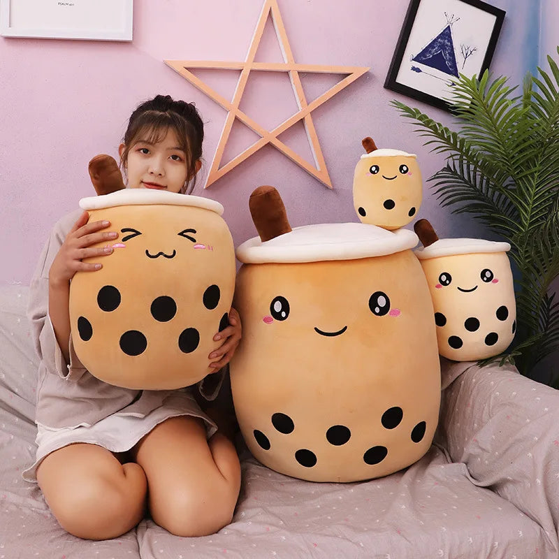 Child holding a plush kawaii bubble tea toy with a pink wall and decorative items in the background