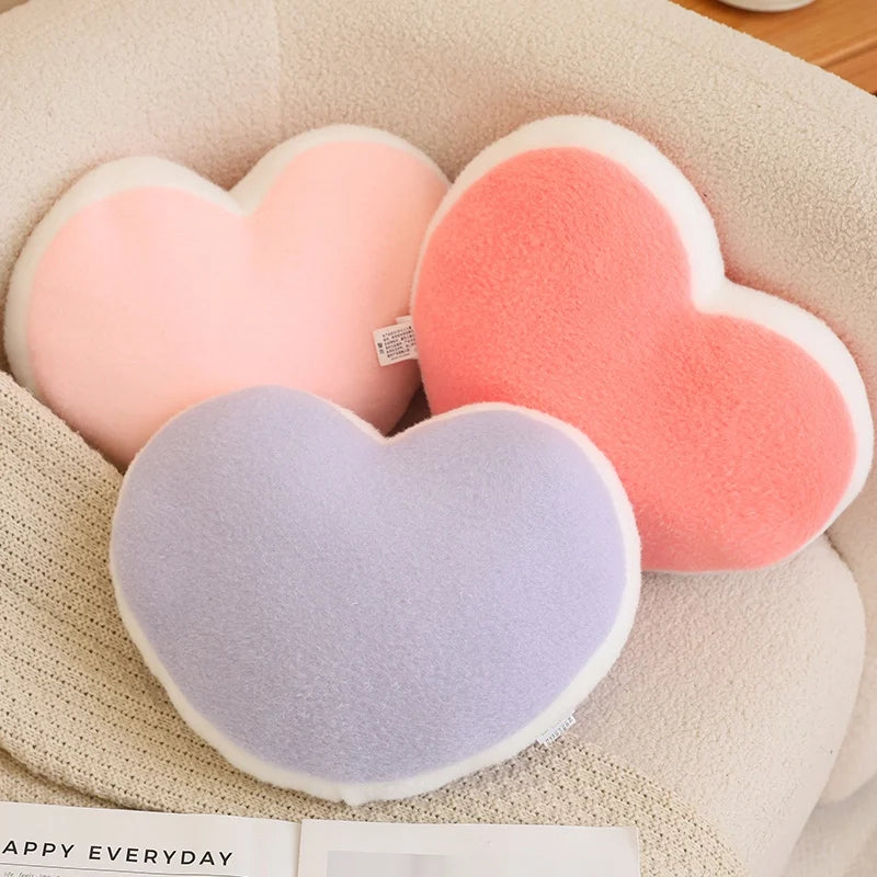 Heart-shaped kawaii cushions in pink and gray on a textured surface with 'Happy Everyday' branding.