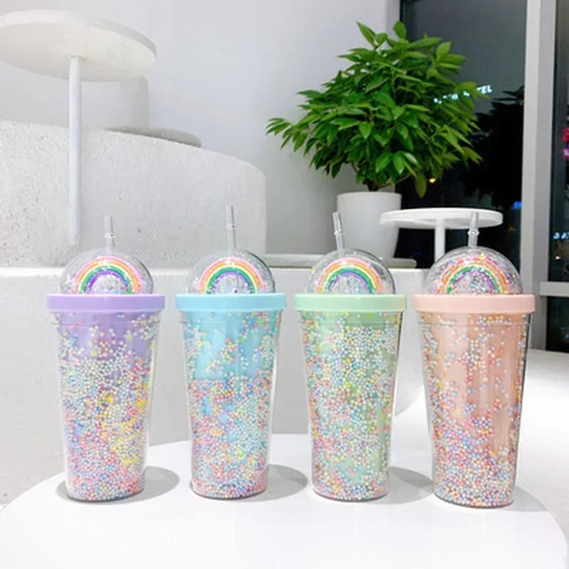 Four glittery kawaii tumblers with rainbow designs on lids in a row.