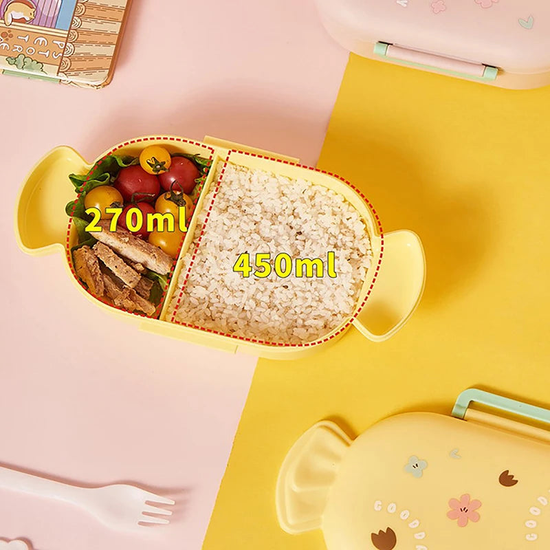 Yellow kawaii bento box with compartments filled with food on a pink and yellow background