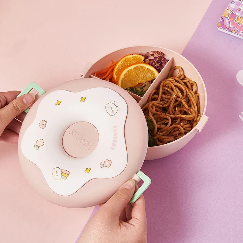 Pink kawaii bento box with food compartments on a pink background