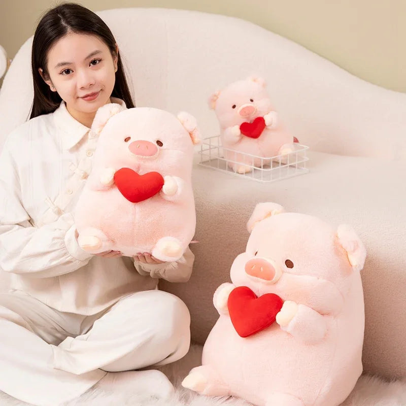Woman holding a kawaii plush pig toy with a red heart, surrounded by similar toys on a couch.