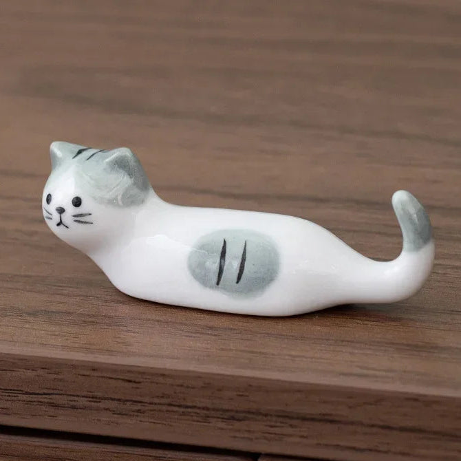 Cat-shaped ceramic kawaii chopstick holders on a wooden surface with dimensions displayed.
