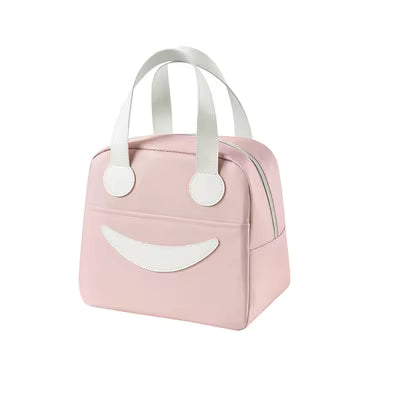 A light pink lunch bag with white handles and a white smiley face design on the front, shown against a plain white background.