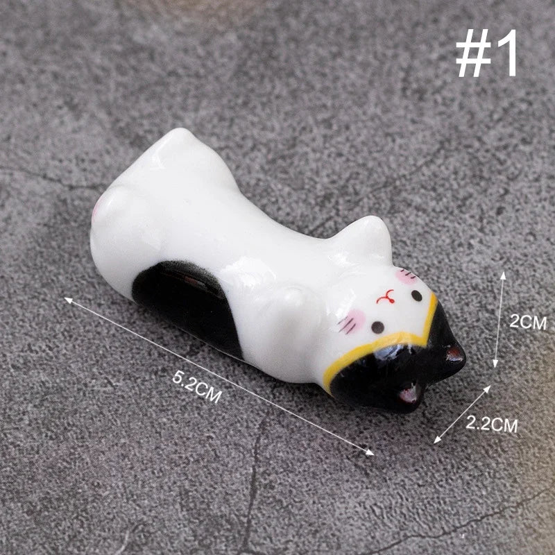 Cat-shaped kawaii chopstick holders with measurements on a gray surface