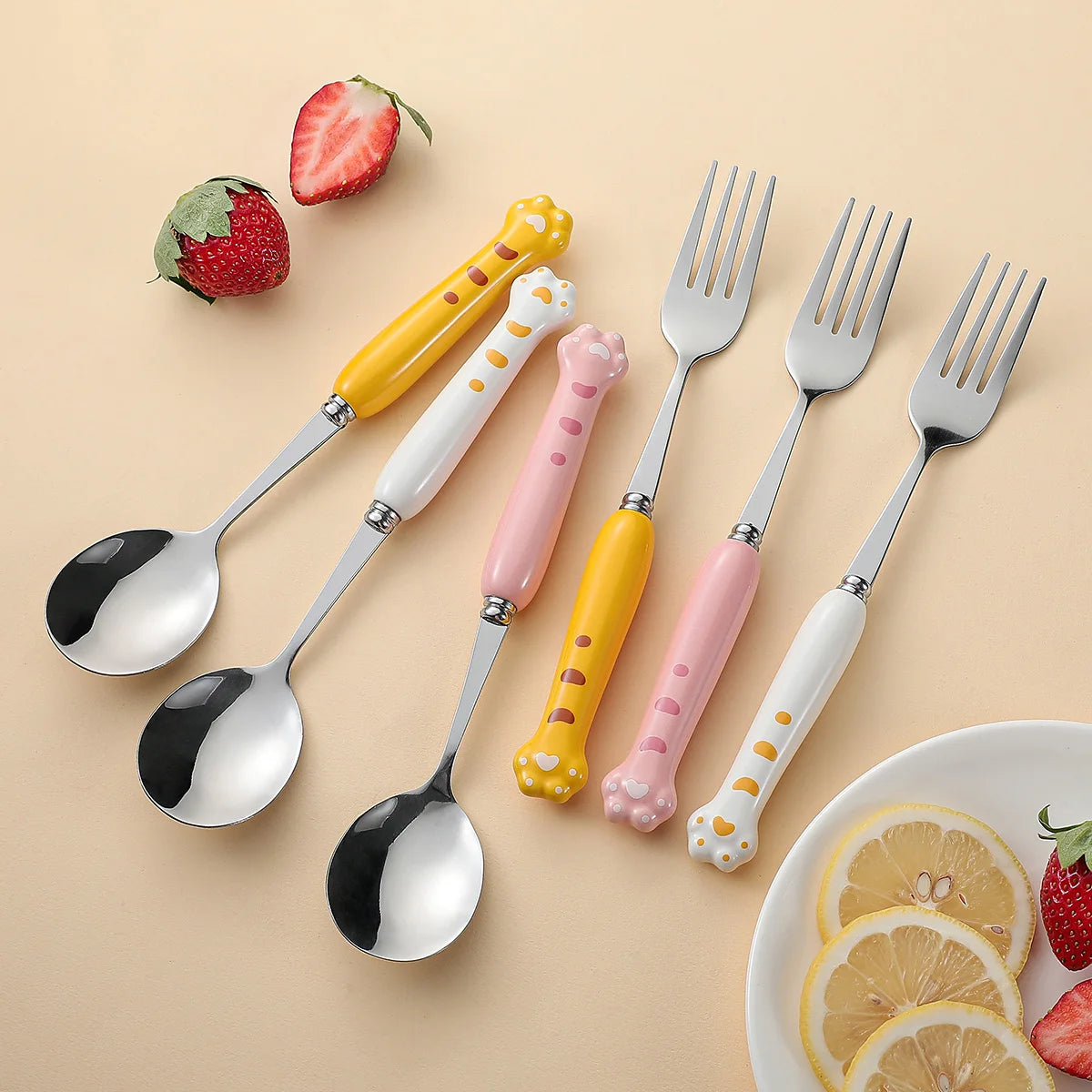Set of colorful kawaii utensils with animal-themed handles on a beige background.