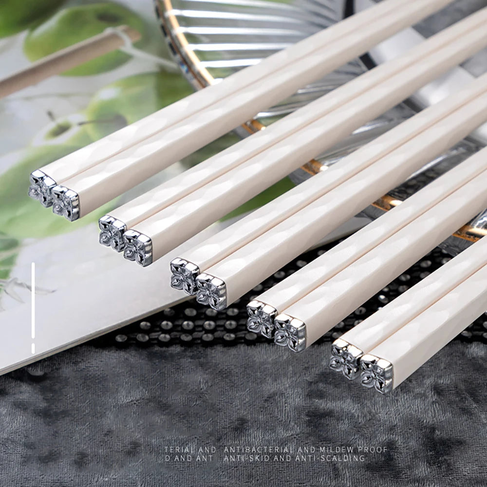 Set of decorative kawaii chopsticks with crystal embellishments on a textured surface.