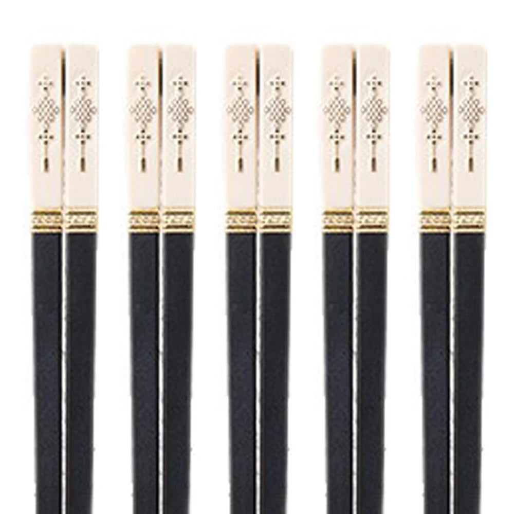 Set of black kawaii chopsticks with gold accents on a white background