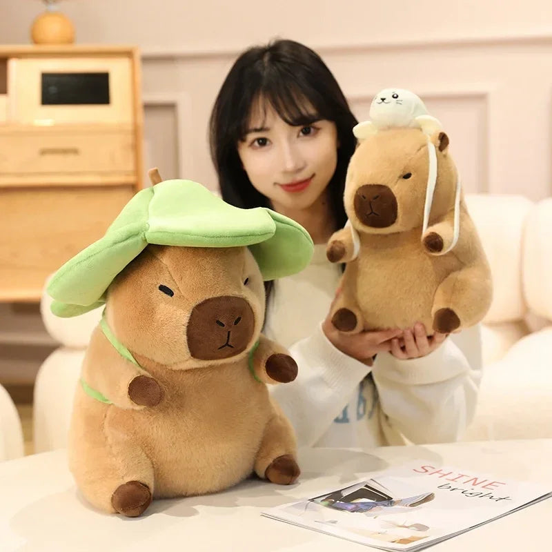 Woman holding two kawaii plush toys resembling animals with a green hat and another with a white object on its head, sitting on a couch.